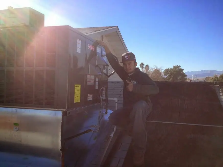HVAC technician performing AC Tune-Up on a rooftop unit in Waveland